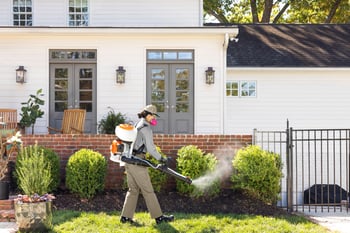Pest control technician treating outside of home for mosquitoes - Keep mosquitoes away from your home with Cooper Pest Control in PA and NJ